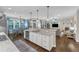 Open kitchen with island seating, stainless steel appliances, and seamless flow into the dining and living areas at 3111 Virginia Pine Ln, Apex, NC 27539