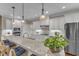 Spacious kitchen island with granite countertop, stainless appliances, and pendant lights with barstool seating at 3111 Virginia Pine Ln, Apex, NC 27539