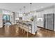Well-lit kitchen featuring a large island with seating, stainless steel appliances, and hardwood floors at 3111 Virginia Pine Ln, Apex, NC 27539