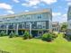 This back exterior shows a lawn, patio, and balcony for outdoor enjoyment at 336 Skymont Dr, Holly Springs, NC 27540