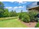 Well-kept backyard with lush lawn, landscaping, and a view of the surrounding greenery at 336 Skymont Dr, Holly Springs, NC 27540