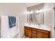 Well lit bathroom featuring a double sink vanity with decorative framed mirrors and chrome fixtures at 336 Skymont Dr, Holly Springs, NC 27540