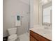 Well-lit bathroom with a shower and vanity with a brown cabinet at 336 Skymont Dr, Holly Springs, NC 27540