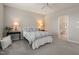 Comfortable bedroom featuring carpet, fan, lamps, and adjoining bathroom access at 336 Skymont Dr, Holly Springs, NC 27540