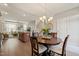 Bright dining area with a chandelier, hardwood floors, and a seamless connection to the living room at 336 Skymont Dr, Holly Springs, NC 27540