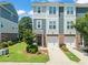 Charming townhome featuring a brick facade, attached garage, and well-maintained landscaping at 336 Skymont Dr, Holly Springs, NC 27540