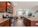 Stylish kitchen featuring granite counters, stainless steel appliances, and an open view into the living room at 336 Skymont Dr, Holly Springs, NC 27540