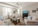 Comfortable living room with plush seating, ceiling fan, and large windows at 336 Skymont Dr, Holly Springs, NC 27540