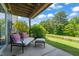 Covered patio space, ideal for enjoying the outdoors with seating and lush greenery at 336 Skymont Dr, Holly Springs, NC 27540