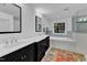 Modern bathroom featuring dual sinks, a bathtub, and a walk-in shower at 425 Morrison Ave, Raleigh, NC 27608
