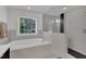 Contemporary bathroom showcasing a tub, separate glass shower, and neutral tiling at 425 Morrison Ave, Raleigh, NC 27608