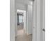 Hallway with neutral tile flooring, white walls, and view into a bedroom at 425 Morrison Ave, Raleigh, NC 27608