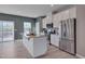 Modern kitchen boasts a granite island, stainless steel appliances, white cabinetry, and a sliding glass door at 445 Brier Summit Pl, Durham, NC 27703