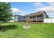 Landscaped backyard with an outdoor fire pit, wooden deck, screened in back porch, hot tub and green lawn at 45 Imperial Dr, Clayton, NC 27527