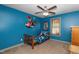 Vibrant bedroom with blue walls, fun decor, ceiling fan, natural light, and neutral carpet at 45 Imperial Dr, Clayton, NC 27527