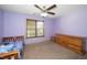 Cozy bedroom with neutral carpet, a ceiling fan, complemented by natural light from the window at 45 Imperial Dr, Clayton, NC 27527
