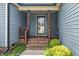 Inviting front porch with brick steps, wood railing, and blue siding at 45 Imperial Dr, Clayton, NC 27527