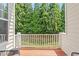 View of the back porch with wood flooring and white railings overlooking the lush green trees at 5003 Celtic Ct, Raleigh, NC 27612