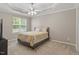 Bedroom featuring a tray ceiling, ceiling fan, and window at 5003 Celtic Ct, Raleigh, NC 27612