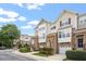 Townhouses with stone accents, garages, tidy landscaping, and sidewalks create welcoming street view at 5003 Celtic Ct, Raleigh, NC 27612
