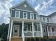 Charming two-story home with a covered front porch, white railing, and a well-manicured lawn at 510 Yeowell Dr, Chapel Hill, NC 27514