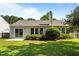 Backyard with patio, green lawn, slider, and mature trees offering shade at 608 Kinship Ln, Apex, NC 27502