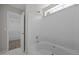 Bright bathroom featuring a tub with a shower and white tiled walls at 608 Kinship Ln, Apex, NC 27502