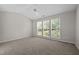 Neutral bedroom with carpet, a vaulted ceiling, and three sunny windows at 608 Kinship Ln, Apex, NC 27502