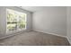 Bright bedroom with large window, neutral carpet and walls, and white trim at 608 Kinship Ln, Apex, NC 27502