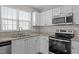 Close-up of a kitchen featuring granite countertops and stainless steel appliances at 608 Kinship Ln, Apex, NC 27502