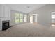 Spacious living room with fireplace, large windows, and a view into the dining area at 608 Kinship Ln, Apex, NC 27502