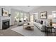 Bright living room showcasing stylish white furnishings, a decorative fireplace, and large windows at 608 Kinship Ln, Apex, NC 27502