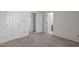 Bedroom with beige carpet and multiple doors and closets offering ample storage at 6131 Summerpointe Pl # 101, Raleigh, NC 27606