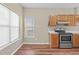 Cozy kitchen features light countertops, wood cabinets, and an open window looking out to the view at 6131 Summerpointe Pl # 101, Raleigh, NC 27606