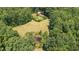 A scenic aerial view highlights a pond and adjacent cleared field near the surrounding forest at 7849 Circle L Trl, Rougemont, NC 27572
