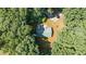 An aerial view of a home with a metal roof nestled in mature trees and featuring an expansive yard at 7849 Circle L Trl, Rougemont, NC 27572