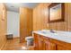Cozy bathroom featuring wood paneling, vanity with sink, toilet, and mirror at 7849 Circle L Trl, Rougemont, NC 27572