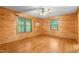 Bedroom with wood walls, hardwood floors, mirror, and windows at 7849 Circle L Trl, Rougemont, NC 27572