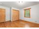 Bedroom features wood floors, trim, and a closet with wooden doors and a window at 7849 Circle L Trl, Rougemont, NC 27572
