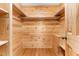 A wood-paneled walk-in closet is equipped with shelving, a bench, and rod for storage at 7849 Circle L Trl, Rougemont, NC 27572