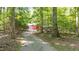 Tree-lined driveway leads to a hidden red barn, offering privacy and seclusion at 7849 Circle L Trl, Rougemont, NC 27572