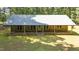 Charming stone home featuring a metal roof, expansive front yard, and inviting covered porch perfect for relaxing outdoors at 7849 Circle L Trl, Rougemont, NC 27572
