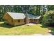 Inviting home exterior with a stone chimney and a lush wooded backdrop provides privacy and nature at 7849 Circle L Trl, Rougemont, NC 27572