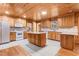 Spacious kitchen featuring a center island, white appliances, wood cabinets, and ample counter space for cooking and entertaining at 7849 Circle L Trl, Rougemont, NC 27572