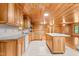 Kitchen with wood ceiling, island, stone countertops, wood cabinets, and tile floors at 7849 Circle L Trl, Rougemont, NC 27572