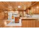 Kitchen with wood ceiling and cabinets, tile floors, island, and stainless refrigerator at 7849 Circle L Trl, Rougemont, NC 27572