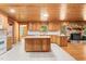 Open kitchen and fireplace with wood cabinets, island, tile floor, and stone fireplace at 7849 Circle L Trl, Rougemont, NC 27572