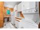 Bright laundry room showcases stacked washer/dryer with wood-paneled walls and natural light at 7849 Circle L Trl, Rougemont, NC 27572
