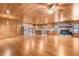Open-concept living area featuring wood walls, wood ceiling, hardwood floors, a stone fireplace, and seamless transition to the kitchen at 7849 Circle L Trl, Rougemont, NC 27572