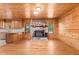 Living room area with wood ceiling and cabinets, stone fireplace, and hardwood floors at 7849 Circle L Trl, Rougemont, NC 27572